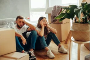 Millcreek Movers sitting on floor looking exhausted while surrounded by moving boxes