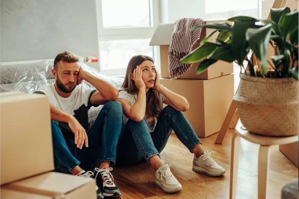Millcreek Movers sitting on floor looking exhausted while surrounded by moving boxes