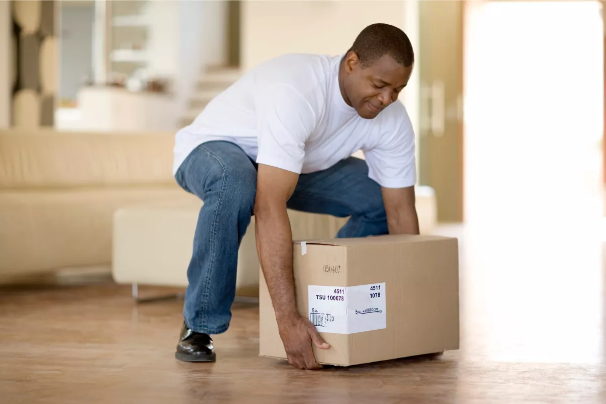 Man picking up box using technique Salt Lake City Movers taught