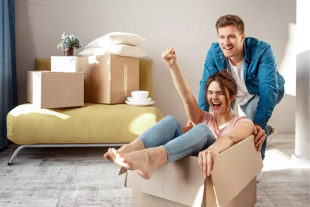 Woman in moving box with fist in the air awaiting Salt Lake City Movers