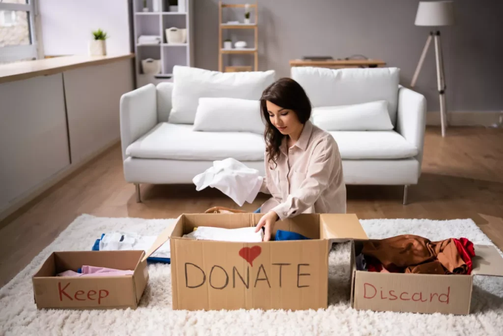 Woman organizing items into keep and discard boxes for West Valley Move.