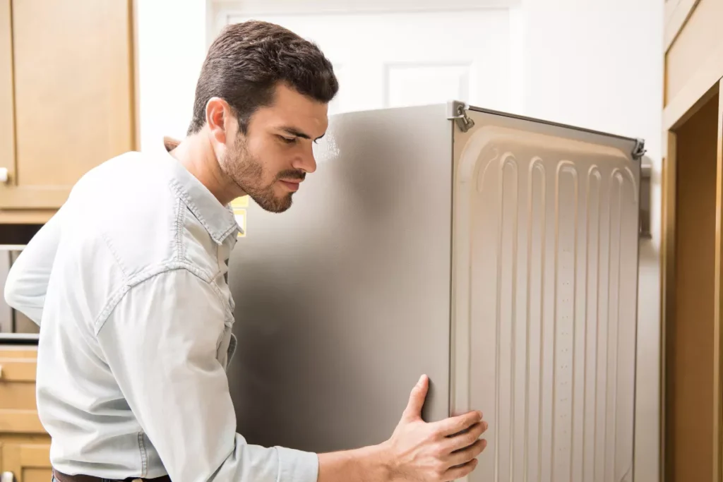 Man moving fridge in Sandy Utah kitchen
